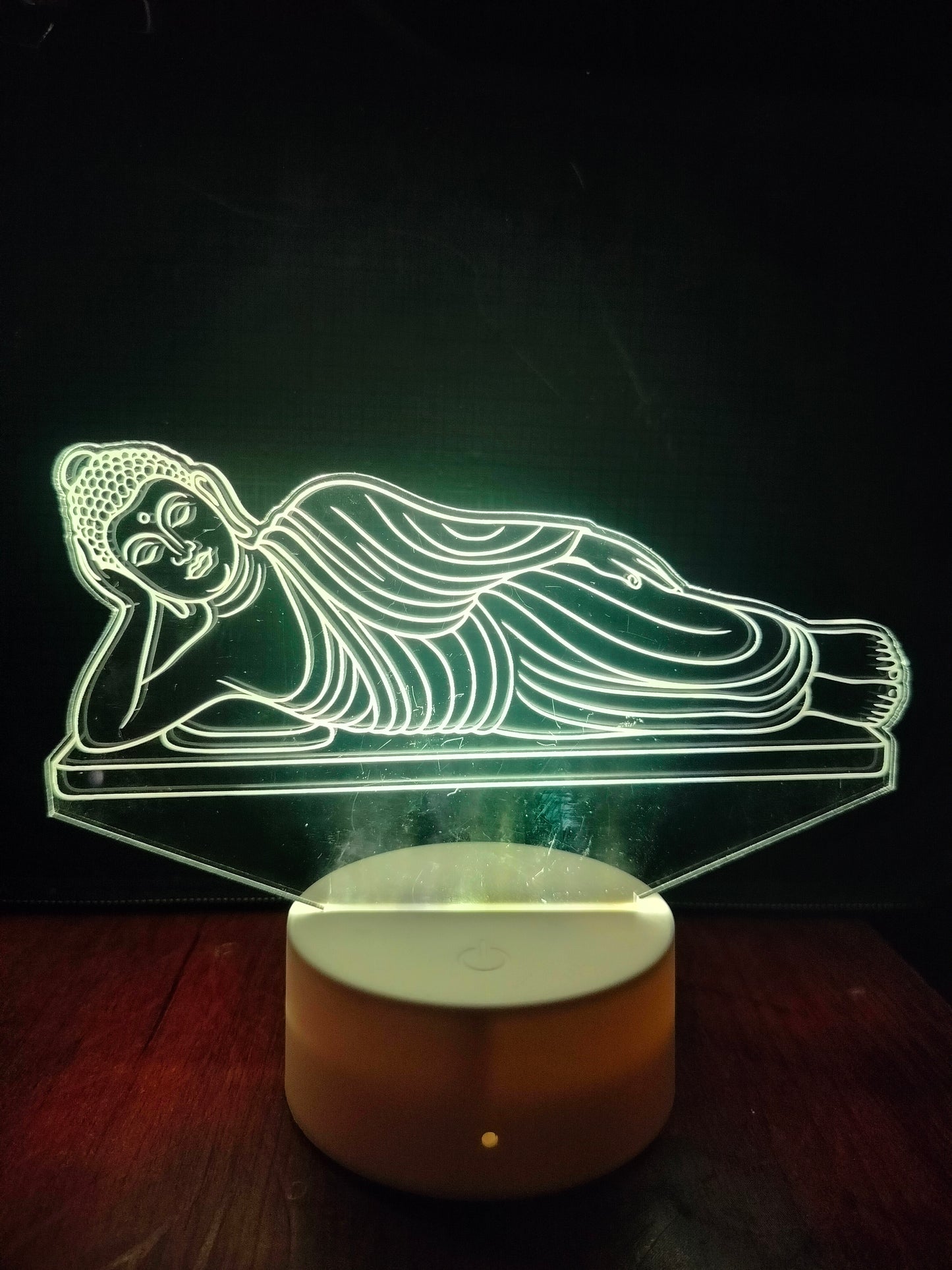 Close-up of Reclining Buddha face in LED lamp
Engraved face detail of Buddha in sleeping pose
Acrylic Buddha lamp showing peaceful facial features
Detailed face view of reclining Buddha in light