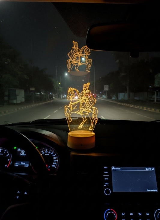 Car interior with a decorative lamp featuring a horse and rider design.
"Illuminated LED 3D illusion figure of Chhatrapati Shivaji Maharaj on horseback, placed on a car dashboard during night travel"LED 3D illusion, Chhatrapati Shivaji Maharaj, on horseback, car dashboard decor.