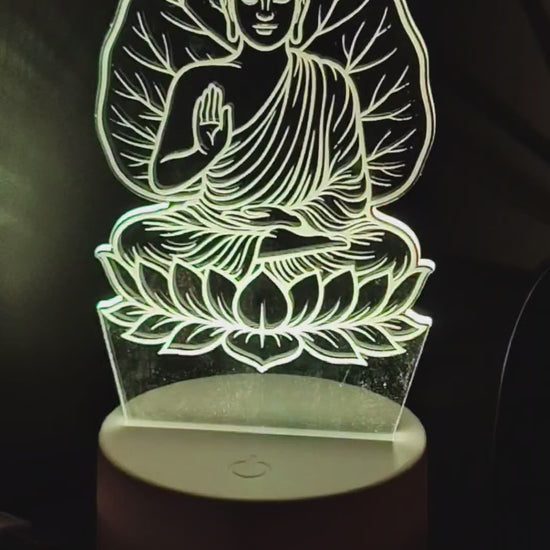 Gautam Buddha 3D Illusion LED lamp glowing softly with blue light by Glow X Art, perfect spiritual decor for meditation and home ambiance, detailed acrylic Buddha design illuminated with vibrant LED lighting, elegant night lamp ideal for gifting and creating peaceful atmosphere, Glow X Art’s unique Buddha lamp for yoga rooms, living spaces, and relaxation, artistic 3D glowing Buddha lamp video showcasing calming effects and intricate laser-cut design.