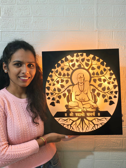 Woman holding a decorative wall art piece with a shree swami samarth  figure and tree design.
Swami Samarth spiritual lighting décor for home
Acrylic black laser cut LED spiritual wall frame
Swami Samarth pooja room backlit wall art